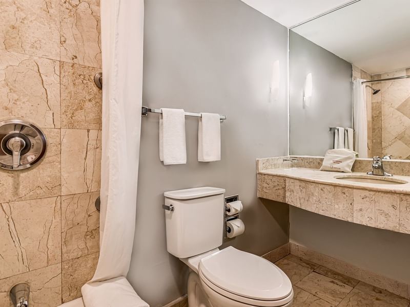 Baño de mármol en Junior Suite, 1 King en Fiesta Inn Express Nuevo Laredo con ducha, WC y lavabo con toallas