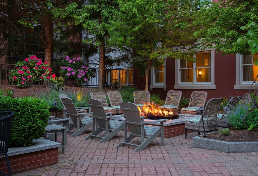 Outdoor patio with chairs around a lit firepit at Portland Harbor Hotel