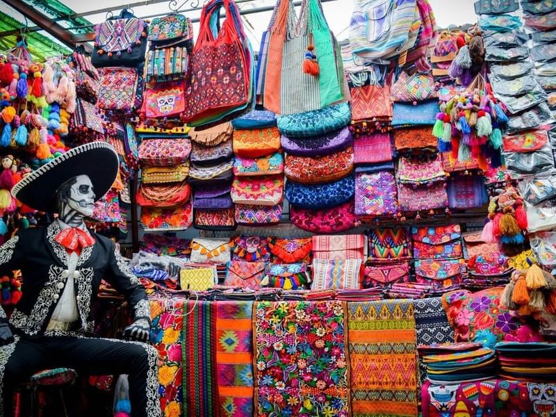 Colorful traditional textiles and crafts on display at a market stall near Fiesta Americana