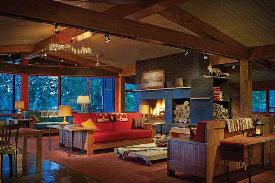Cozy, rustic-style lounge area with red couches and a fireplace, perfect for relaxing at High Peaks Resort