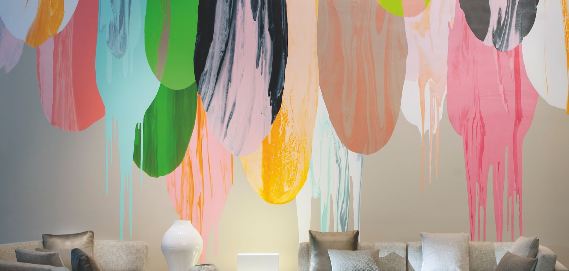 A lobby space with a wall with painting at Melbourne Hotel