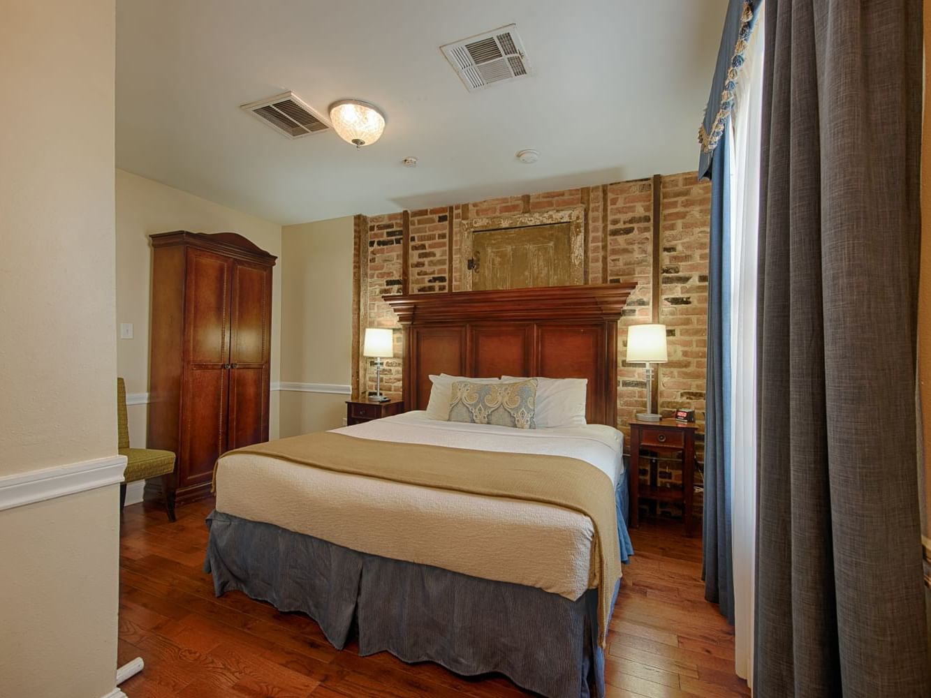 King bed & brick wall in Classic King Room at Hotel St. Pierre