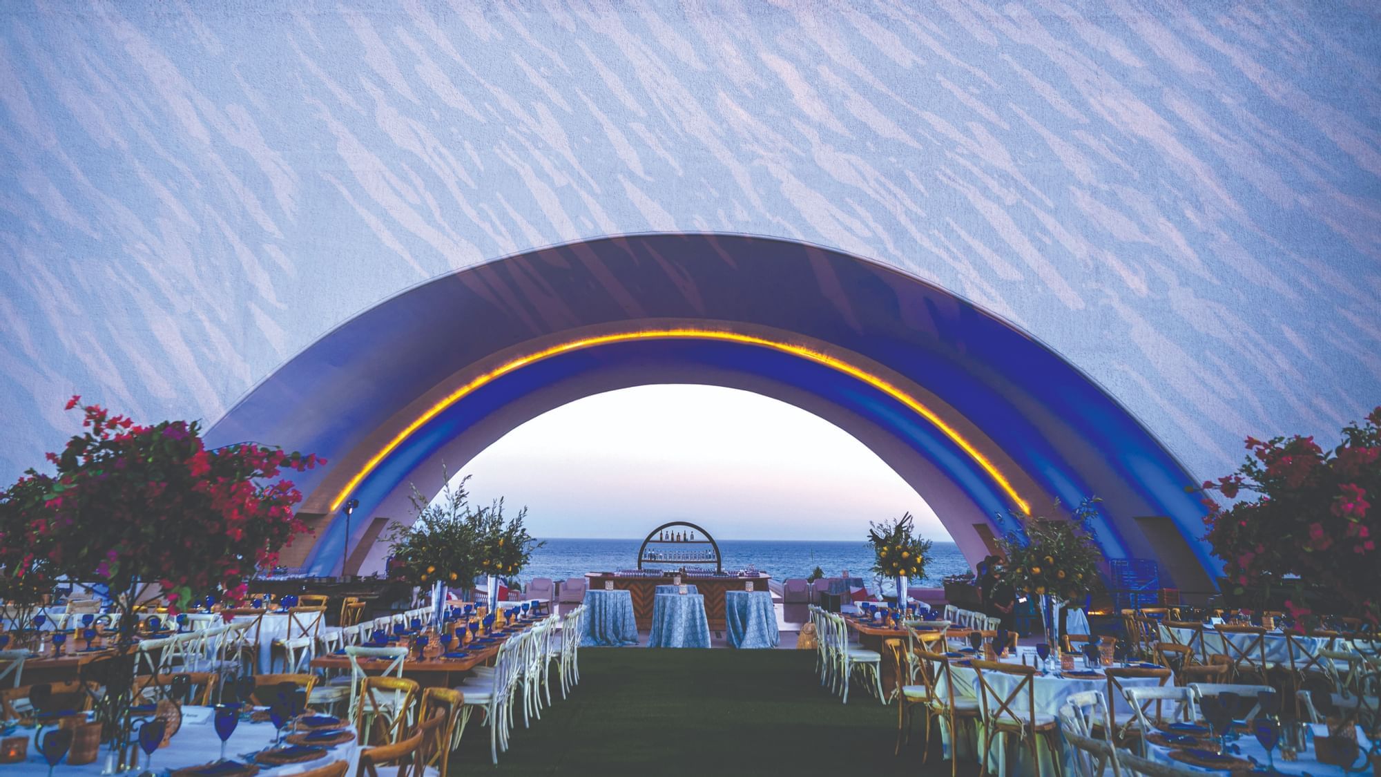Outdoor table setup with floral arrangements and an arch at Marquis Los Cabos