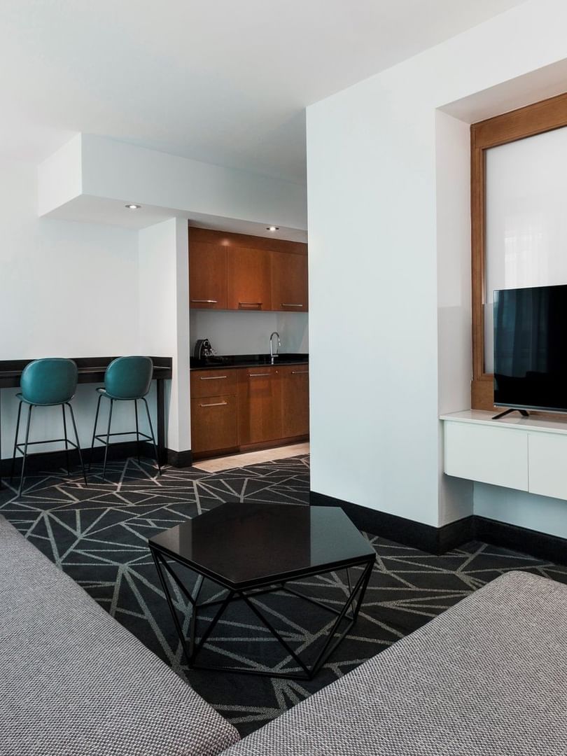 Espace de vie avec télévision et coin repas dans la suite junior du Warwick Le Crystal