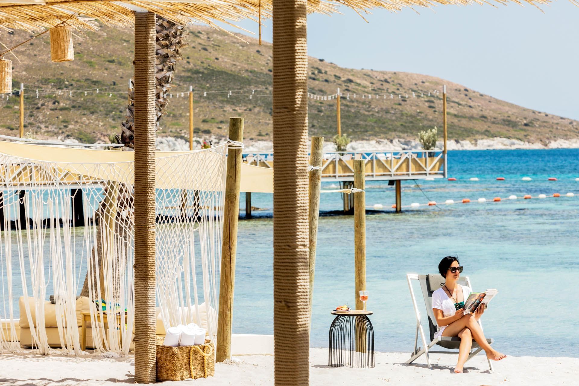 A lady reading by the beach at Kairaba Hotel