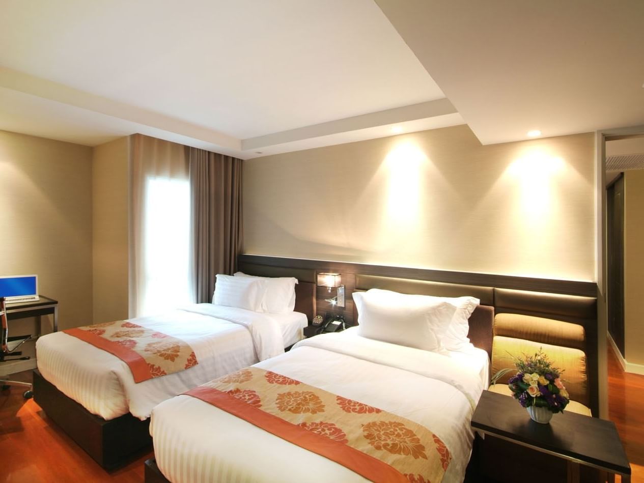 Two beds & working desk in Neo Executive room at Amora Hotel