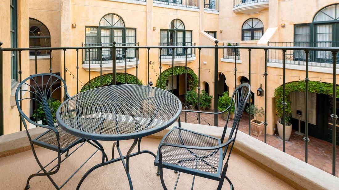 Outdoor balcony with a table and chairs at Deluxe Queen Mobility and Hearing Accessible with Roll-In Shower in El Prado Hotel