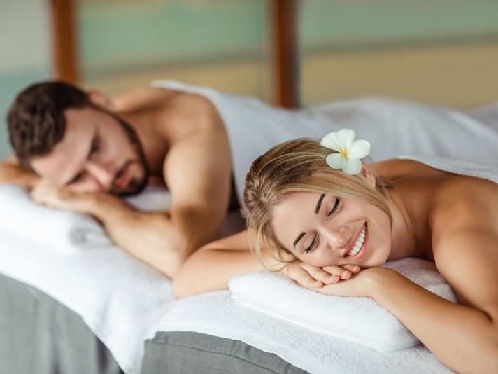 A couple relaxing on treatment beds at Amatara Wellness Resort
