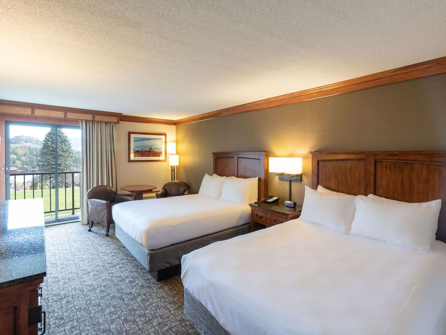 Double Queen Room at the Lake Placid Club Grandview, featuring two queen beds and a glass door leading to a private balcony