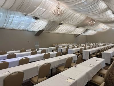 Classroom-style table set-up under a beautifully draped ceiling in a meeting room at Lake Natoma Inn