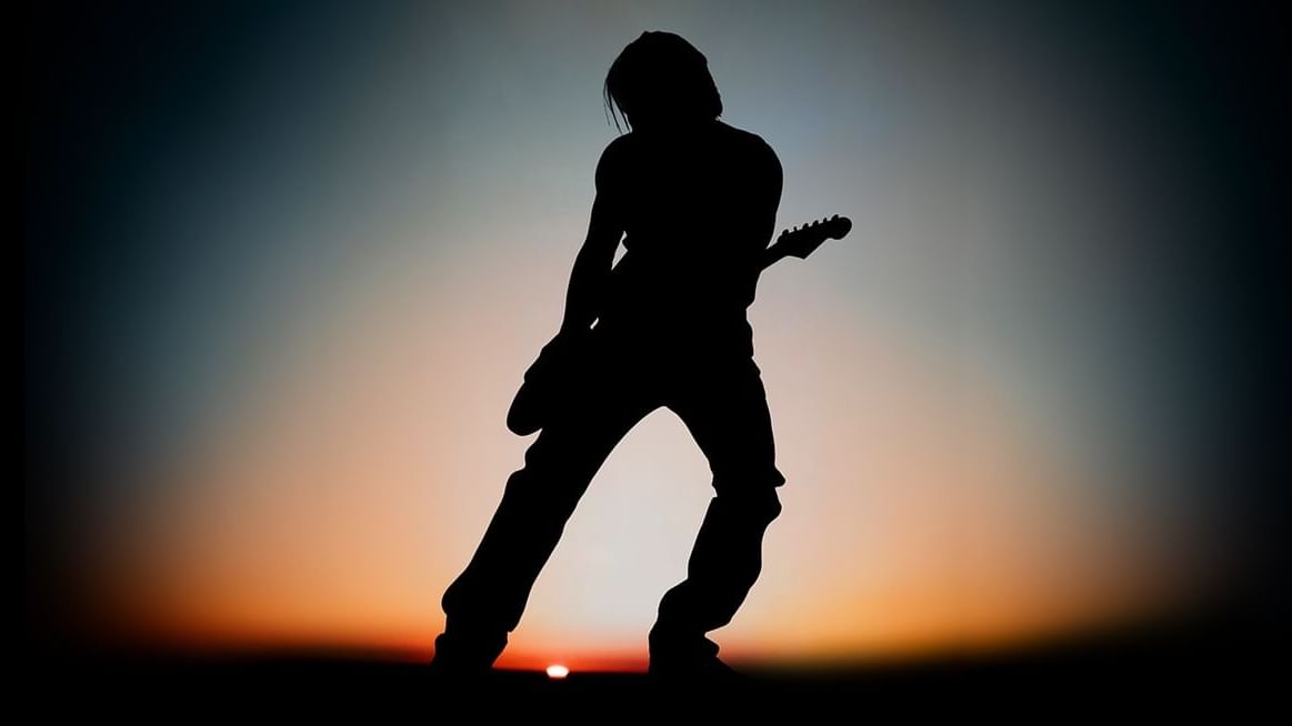 Keith Urban performing live on stage with guitar under bright stage lights