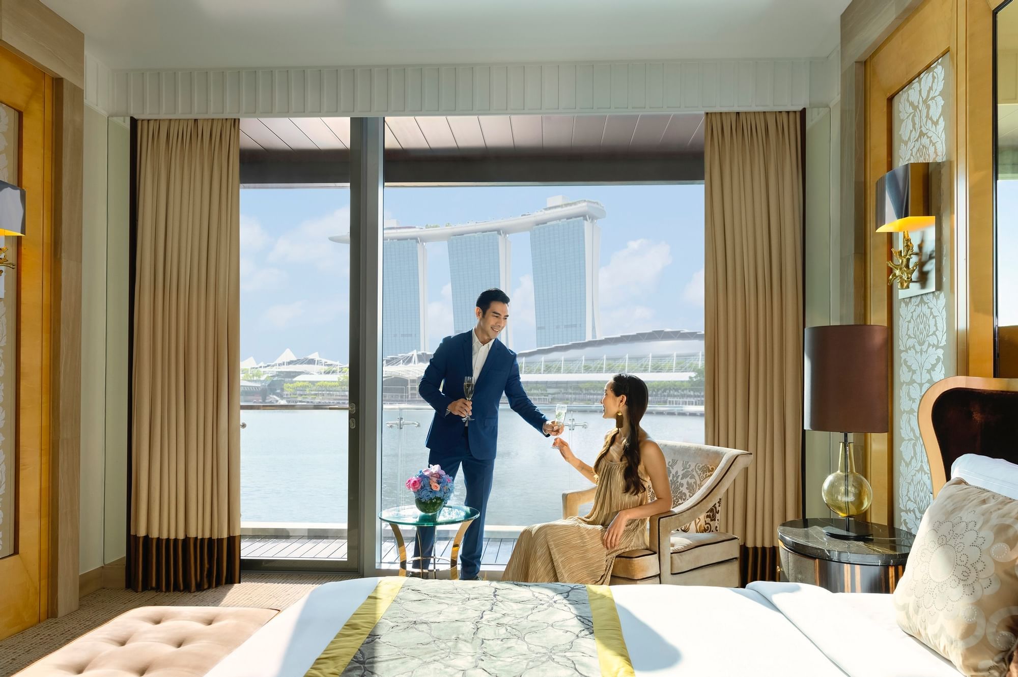 Couple enjoying champagne in a room at Fullerton Bay Singapore