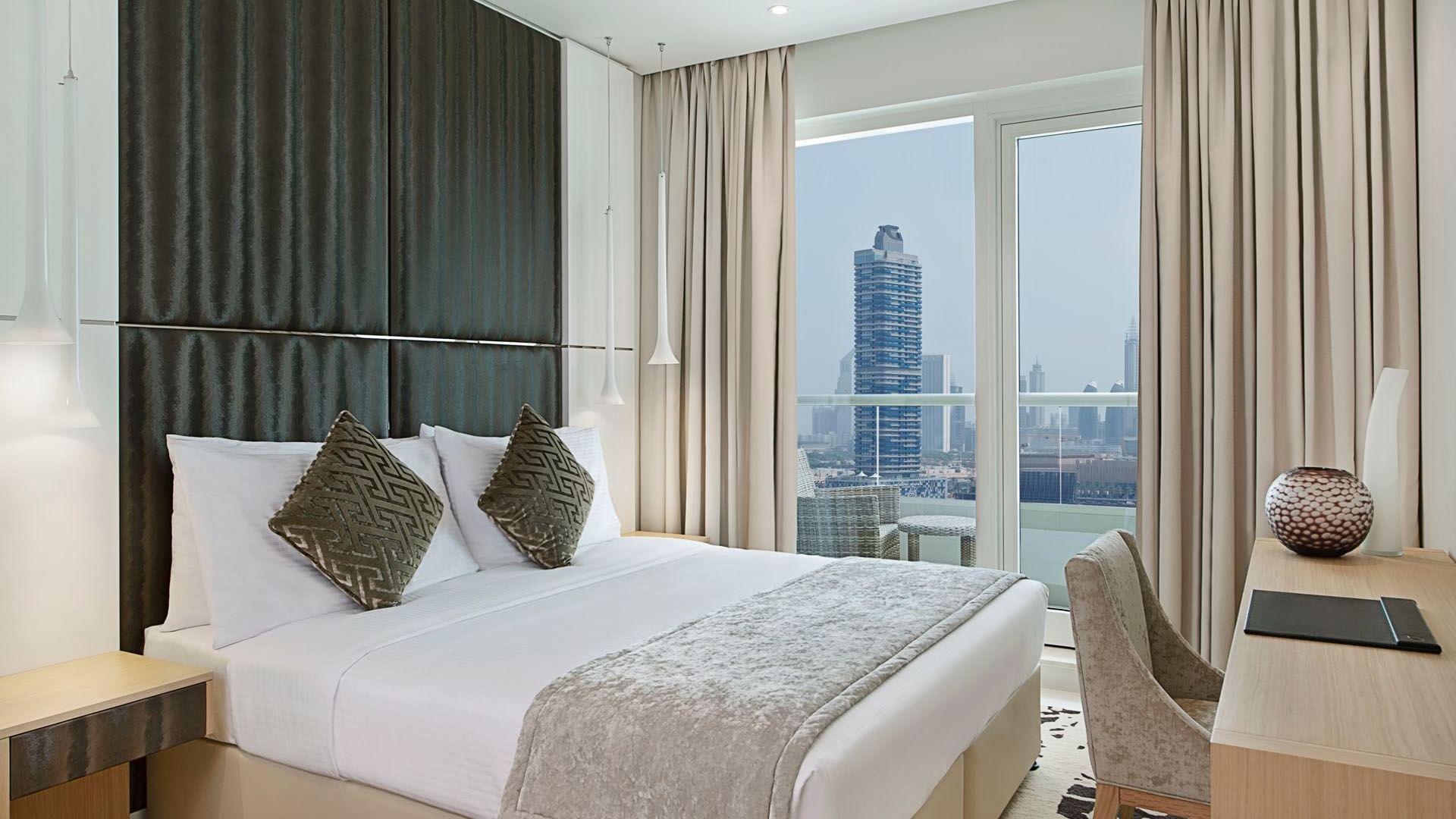 One Bedroom Suite with a king-sized bed and balcony at DAMAC Maison Canal Views
