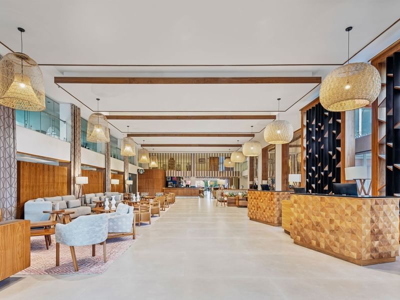Spacious, modern lobby at Fiesta Americana, featuring rattan light fixtures and a warm, inviting ambiance
