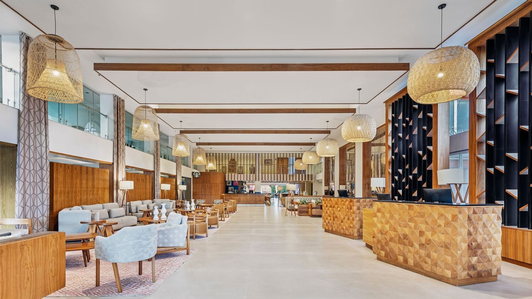 Spacious, modern lobby at Fiesta Americana, featuring rattan light fixtures and a warm, inviting ambiance