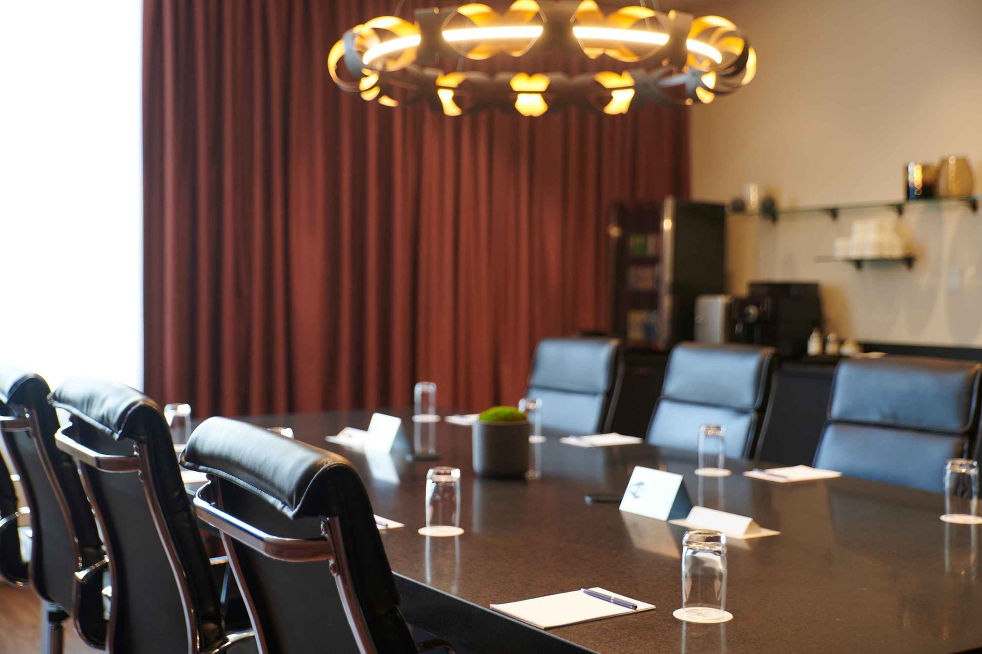 Professional boardroom table with glasses and notepads in Salon Du Président at Warwick Hotels and Resorts