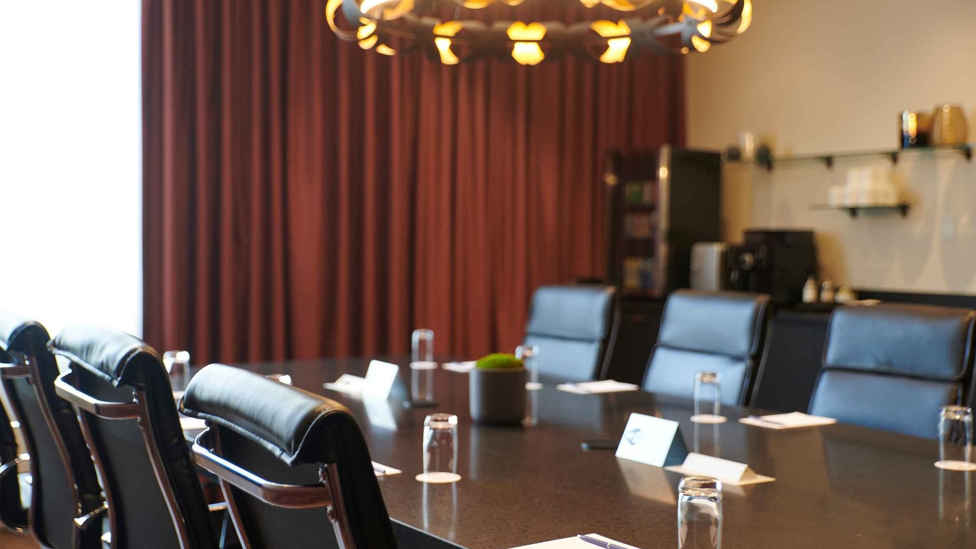 Professional boardroom table with glasses and notepads in Salon Du Président at Warwick Hotels and Resorts