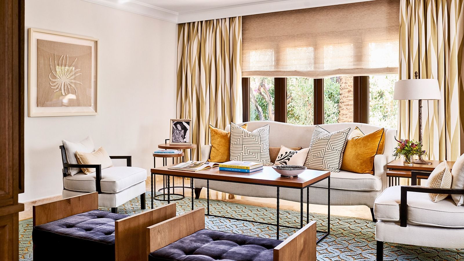 Maria Luisa living area with a  sofa, velvet and patterned pillows, and a coffee table on a blue rug at Marbella Club