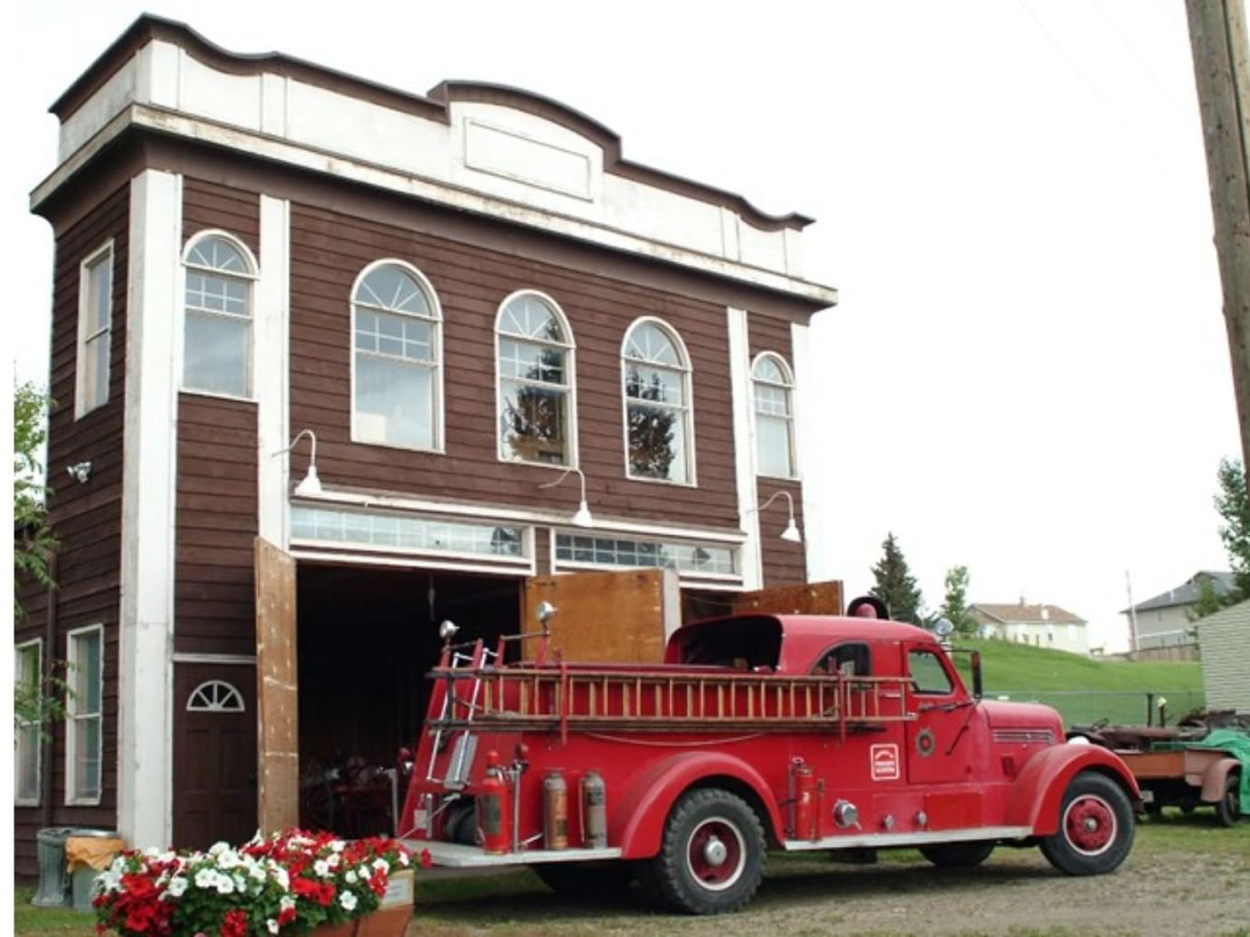 an old red firetruck next to a building