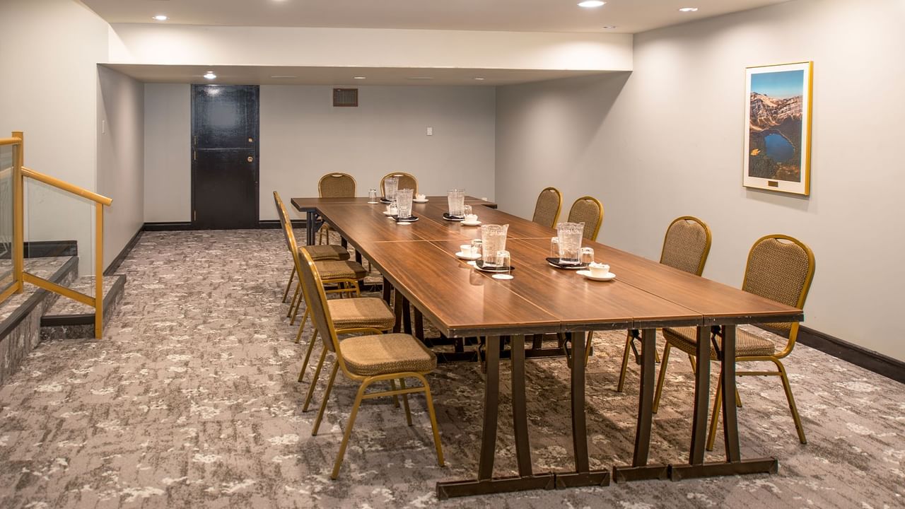 A long wooden table with chairs in a conference room