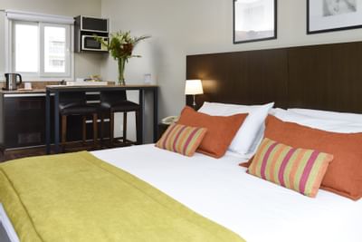 Cama King en el dormitorio de la suite Studio en Argenta Suites