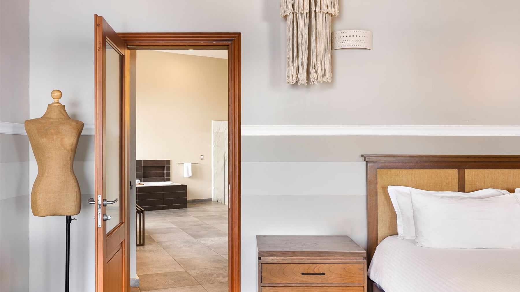 Bed with a bedside table, and a dressing mannequin in a room at Curamoria Collection