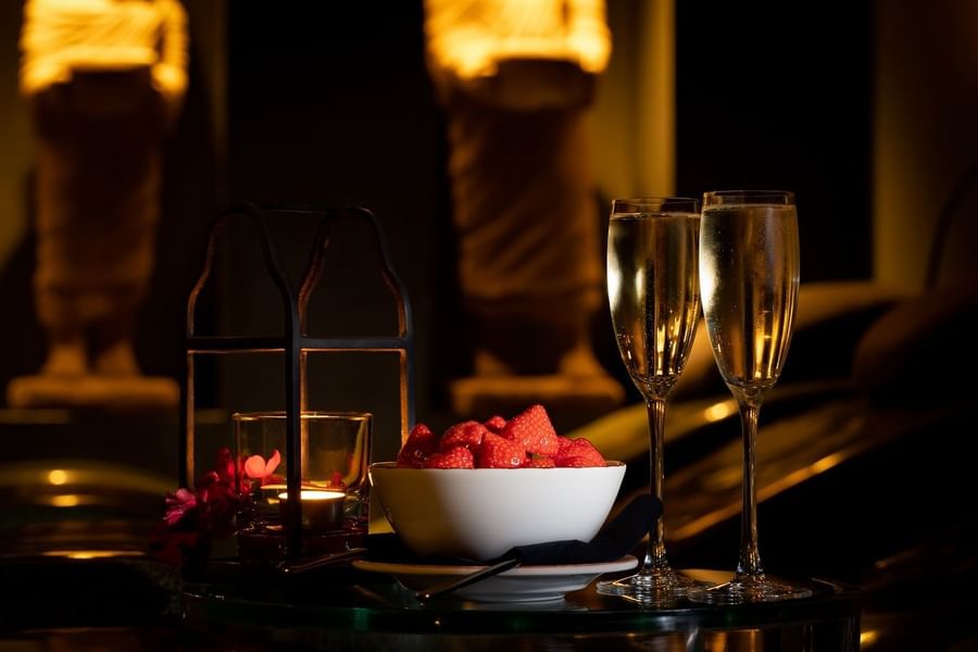 Dinner table with two glasses of wine and strawberries served at The May Fair Hotel