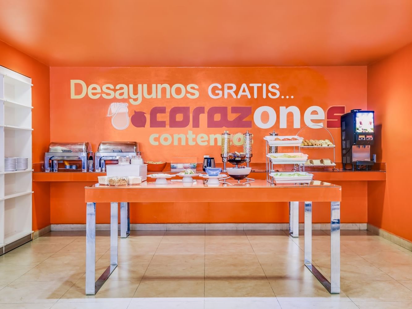 Desayuno organizado en un restaurante con temática naranja en One Hotels.