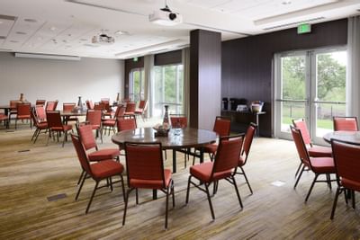 large conference room with circular tables and red chairs