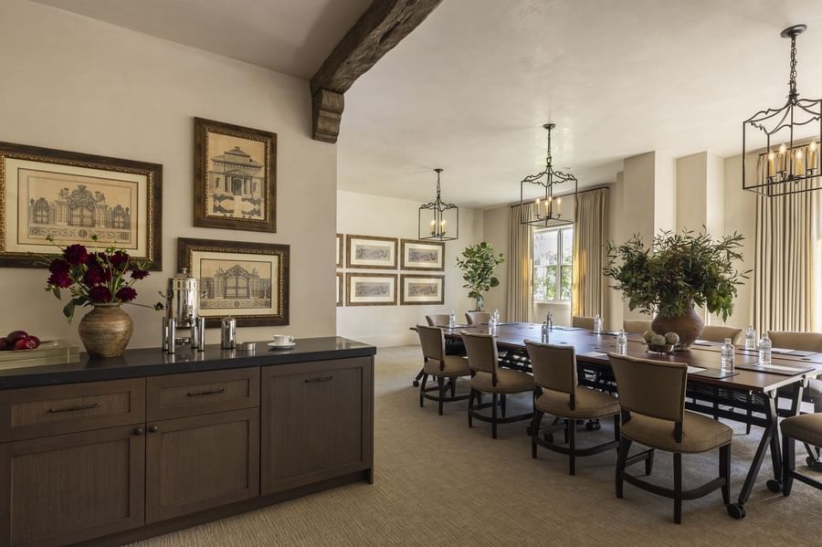 The Jessamine Room at Granduca Houston, with a long table, sleek lighting, wall art, and a side cabinet in a stylish setting