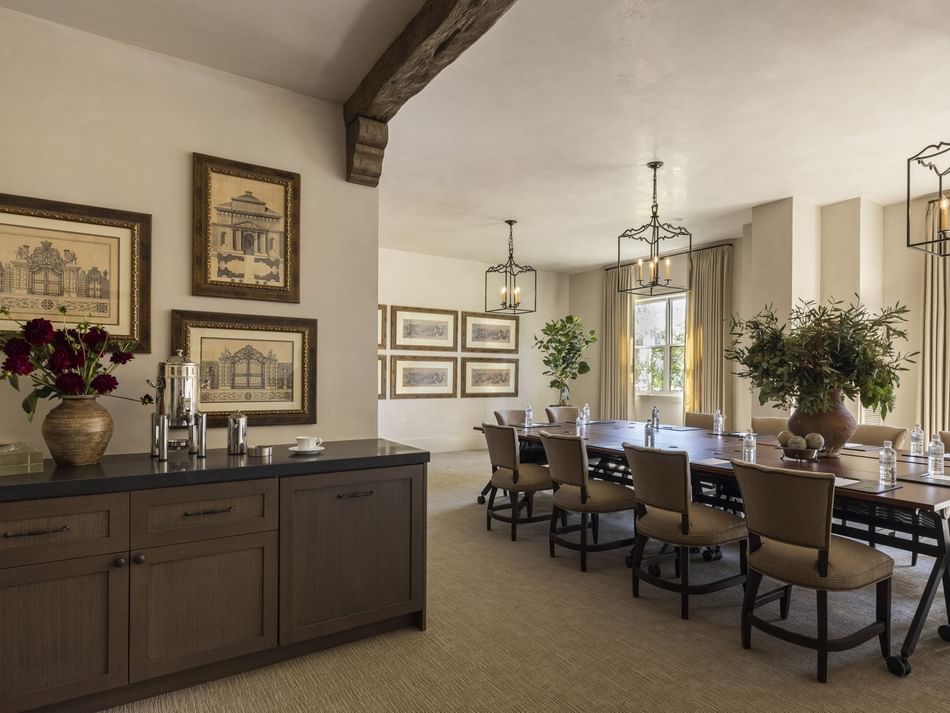 The Jessamine Room at Granduca Houston, with a long table, sleek lighting, wall art, and a side cabinet in a stylish setting