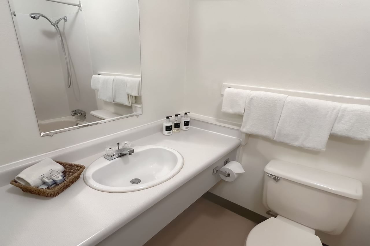 Bathroom with towels, toilet, mirror, sink