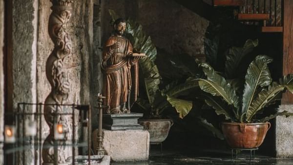 Hermosa estatua de piedra de una figura religiosa, que realza la atmósfera histórica en Casa Santo Domingo
