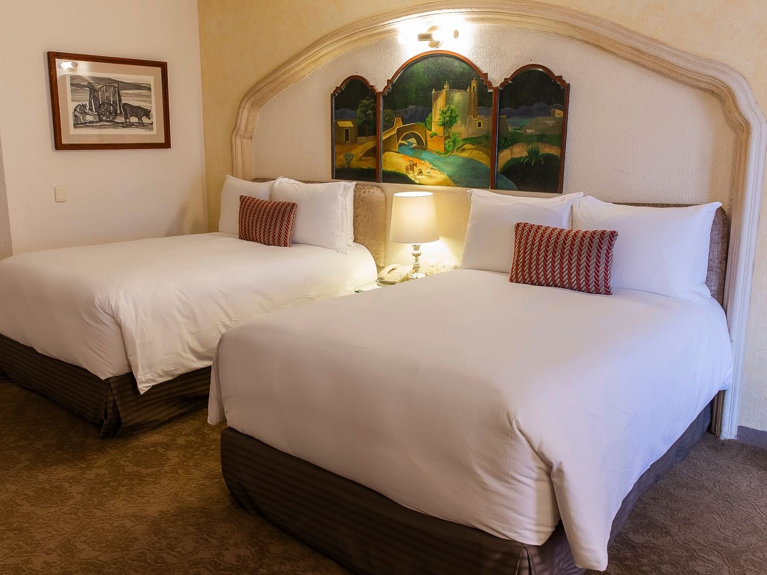 Grand Class room with two double beds, arched alcove with decorative screen, and colonial artwork at Quinta Real Zacatecas