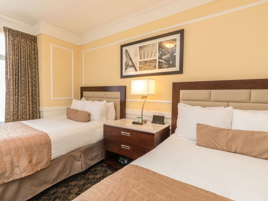 Two comfortable beds with nightstand and lamp at Pickwick San Francisco.