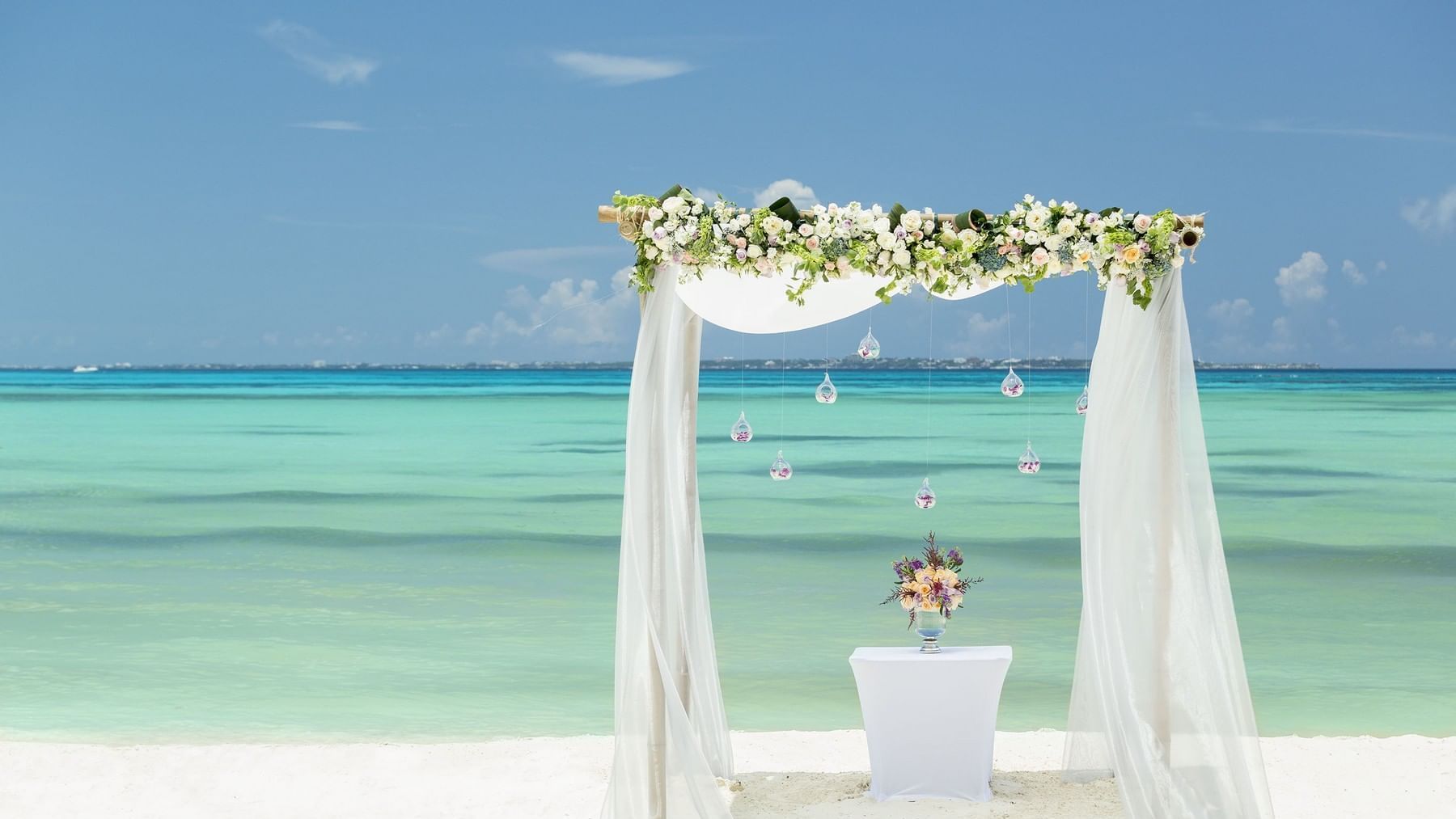 Beach wedding arch with flowers at Grand Fiesta Americana
