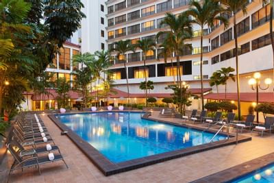 Exterior view of York Hotel Singapore with outdoor pool & sun loungers