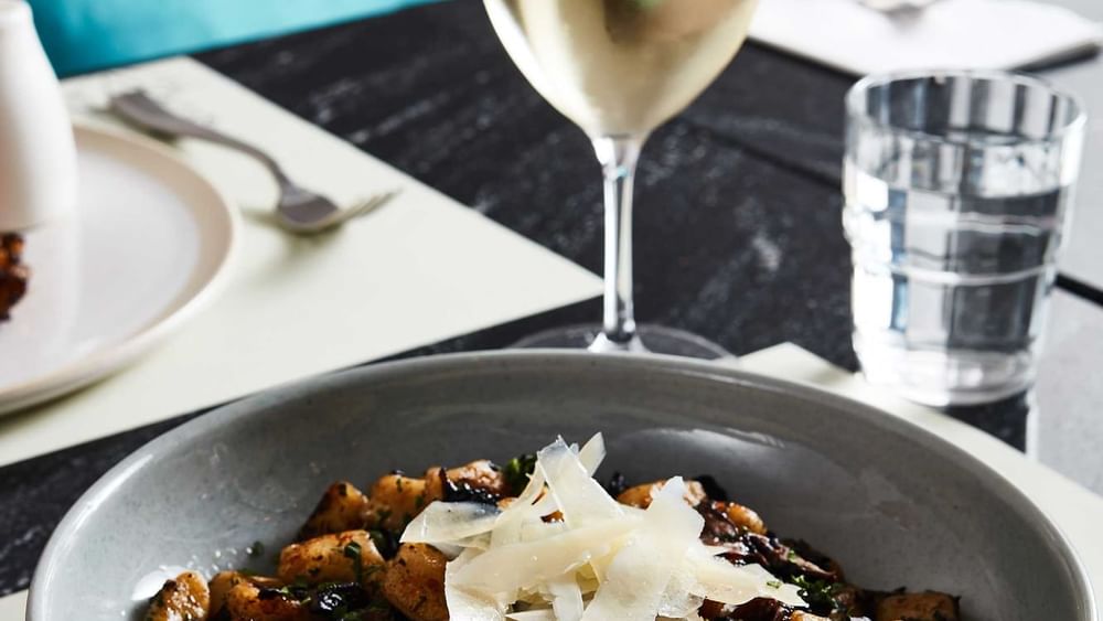 Beef cheek gnocchi dish served with wine at Melbourne Central