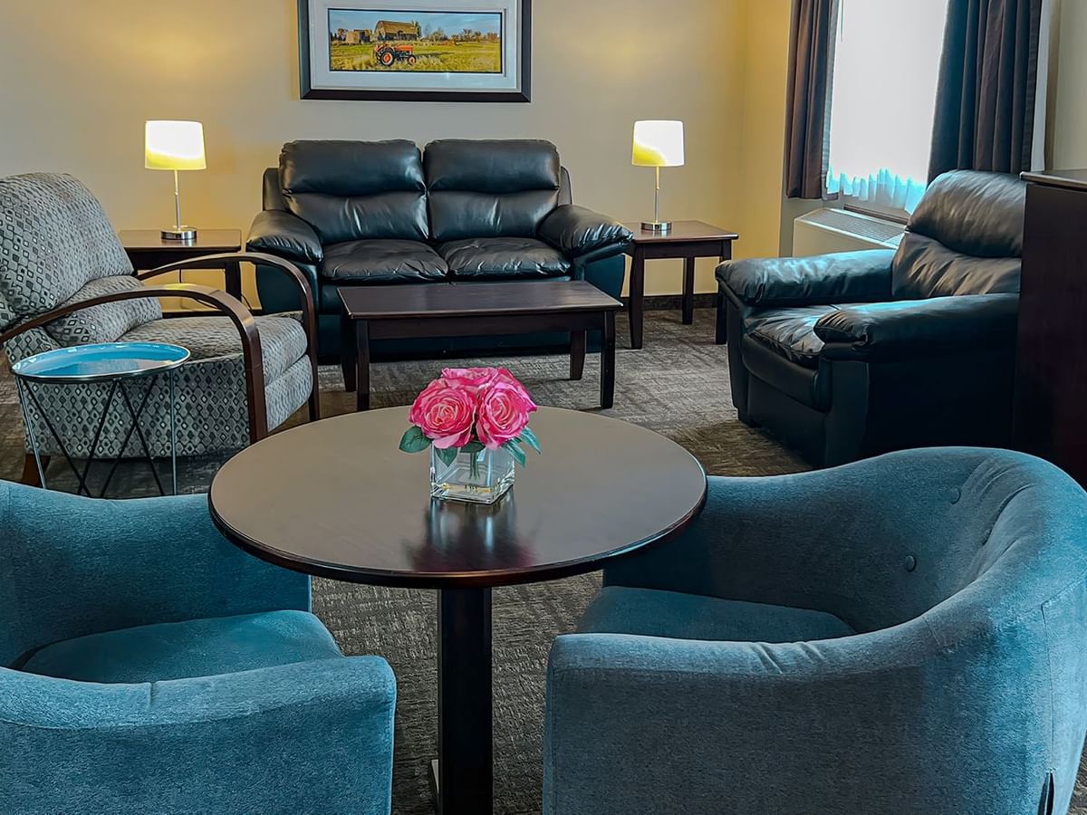 Lounge couches, tables, tv, and flowers in a hotel suite