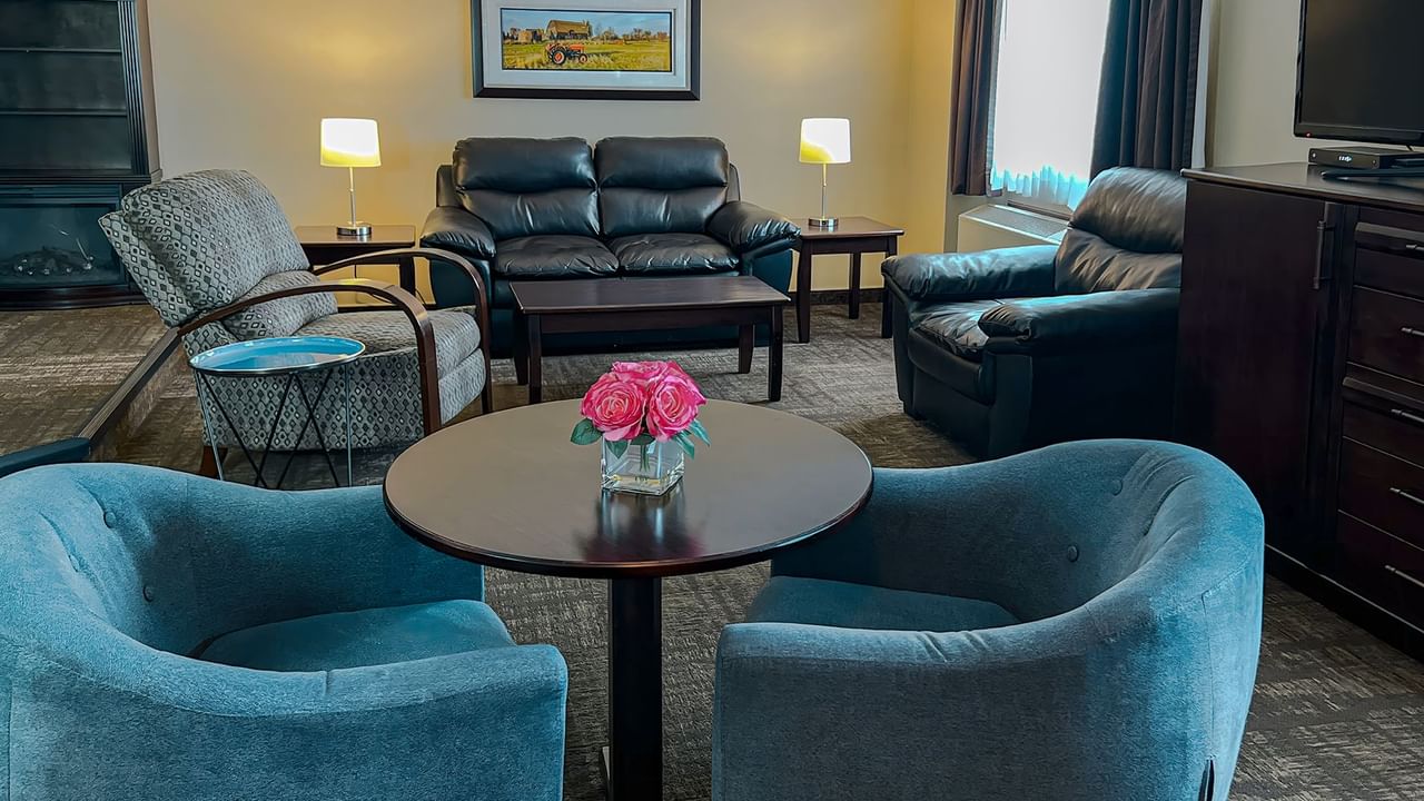 Lounge couches, tables, tv, and flowers in a hotel suite