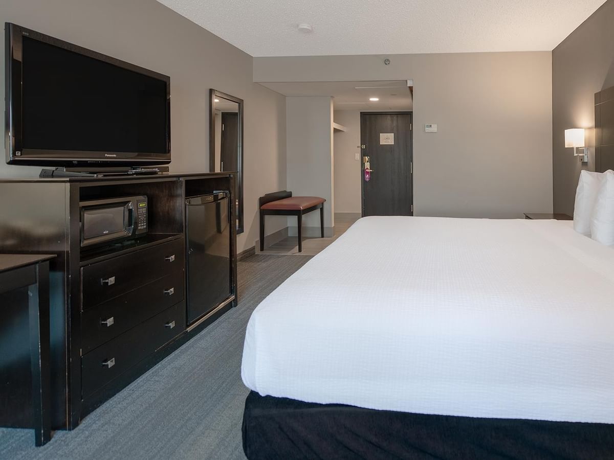 Hotel room with a king-sized bed and a TV.