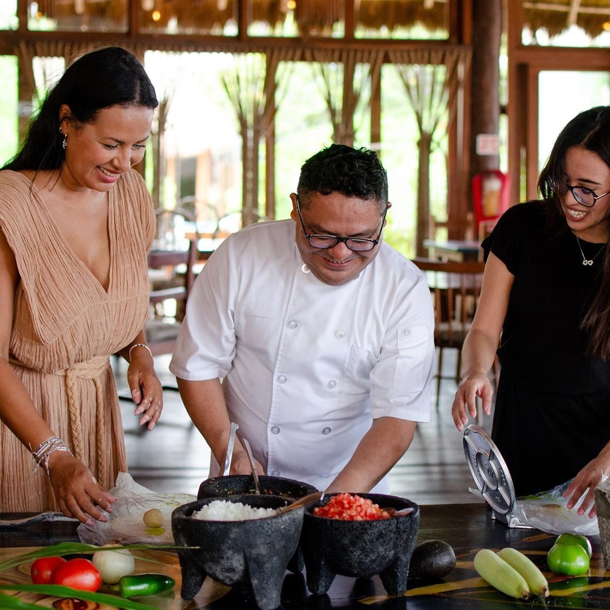 Guests smiling while learning to make authentic Mexican food with a chef at La Zebra Hotel Salsa Workshop