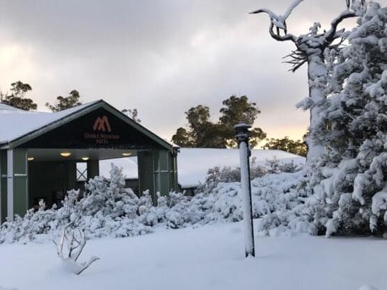 Exterior view of Cradle Mountain Hotel façade covered with snow