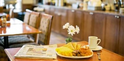 Complimentary Hot Buffet Breakfast served next to a newspaper at Service Plus Inns & Suites Drayton Valley