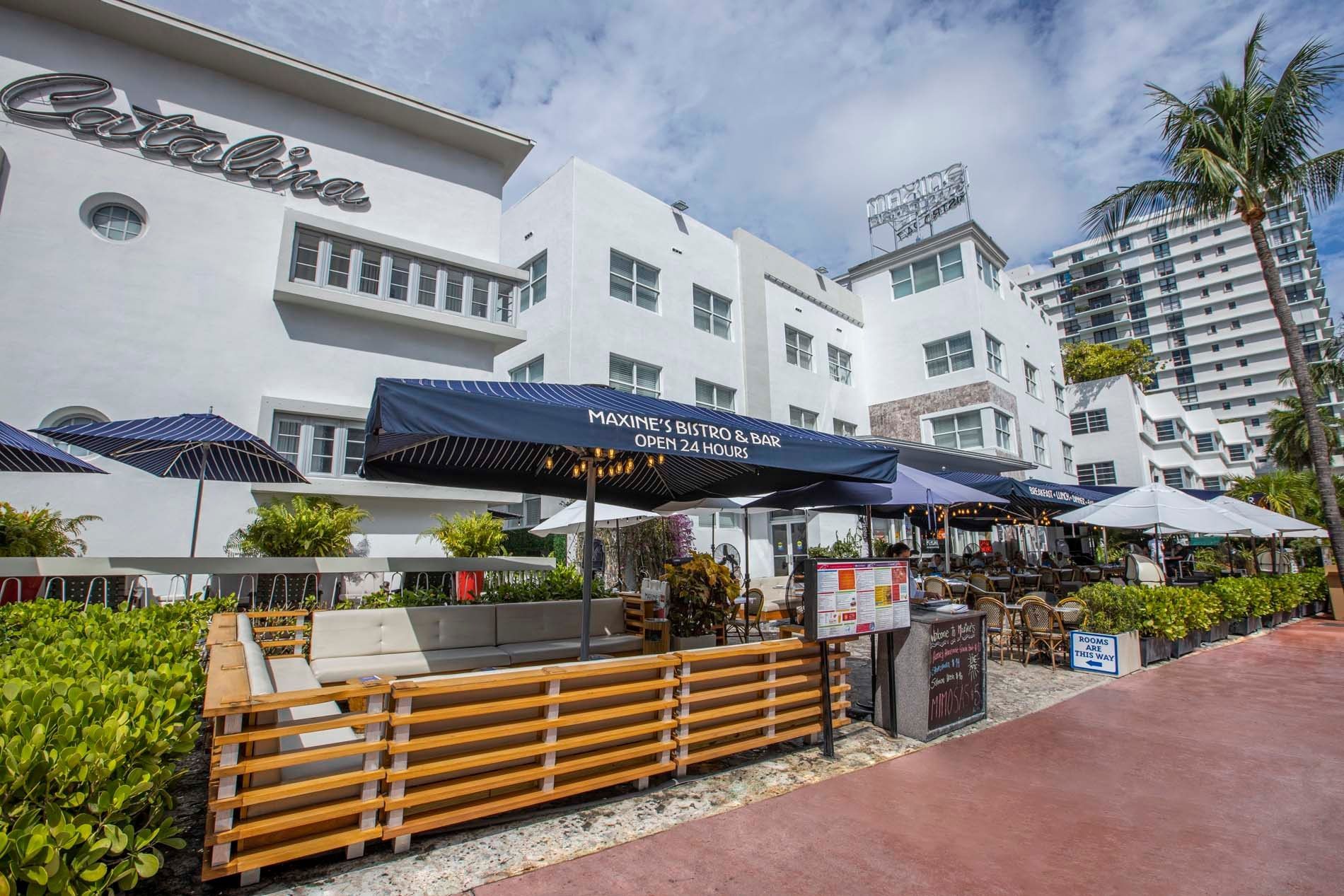 A white building with a blue umbrella and outdoor seating area.
