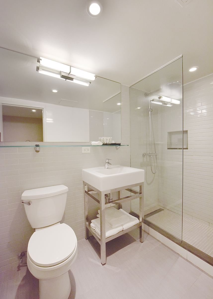 A clean and modern bathroom with a toilet, sink, and shower.