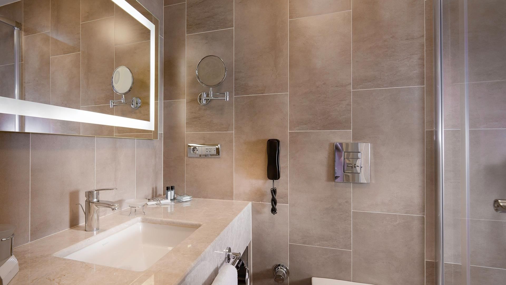 Titanic Comfort Şişli’deki Superior Oda’nın şık donanımlara sahip modern banyosunun iç mekânı.