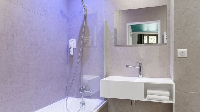 Vanity & bathtub in bathroom of a room at The Originals Hotels