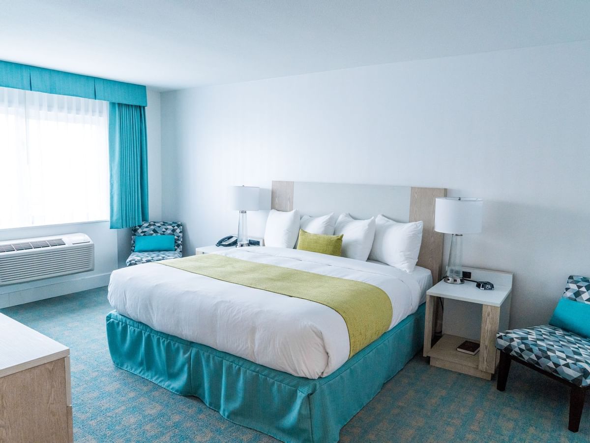 Bed in hotel room with green and blue colors