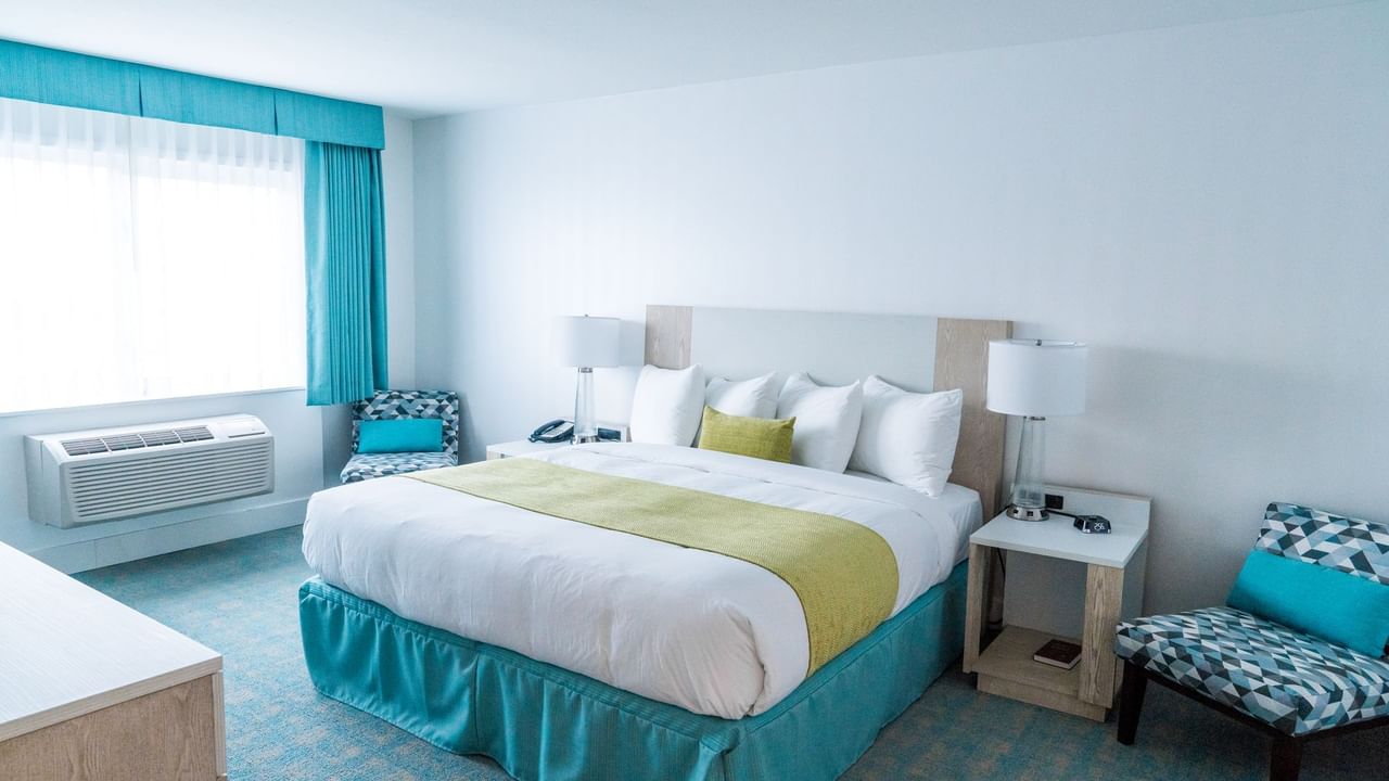 Bed in hotel room with green and blue colors